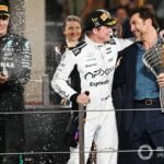 George Russell, Mercedes-AMG F1 Team, Brad Pitt, and Javier Bardem film a scene for an F1 movie on the podium.